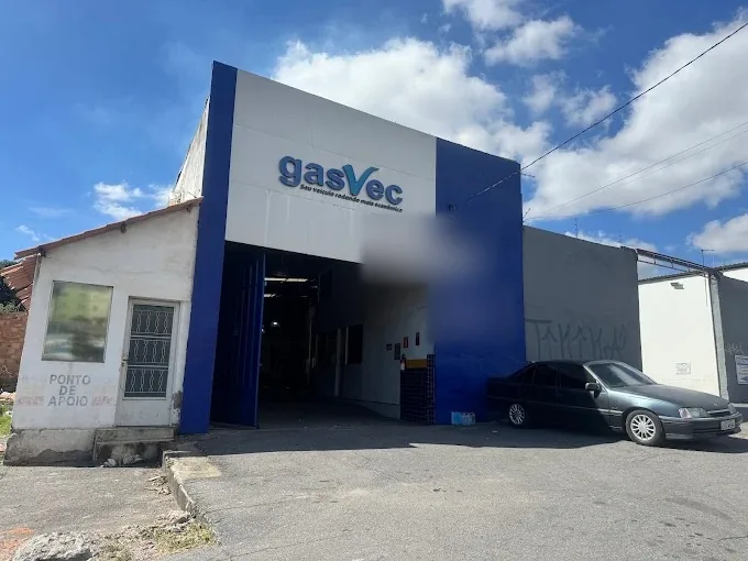 Fachada da oficina Gasvec: galpão com frente azul e branca, o letreiro da Gasvec acima do portão de entrada.
